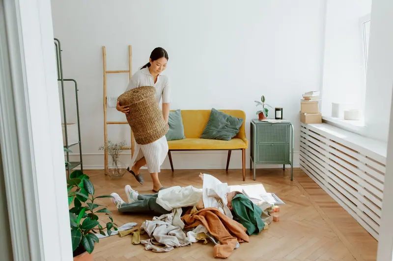 Frau räumt ein Zimmer aus und sortiert Kleidung – Entrümpelung Celle