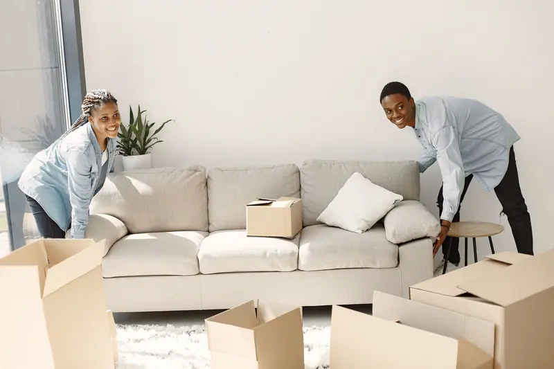 Paar trägt ein Sofa aus dem Wohnzimmer – Privatumzug Wolfenbüttel
