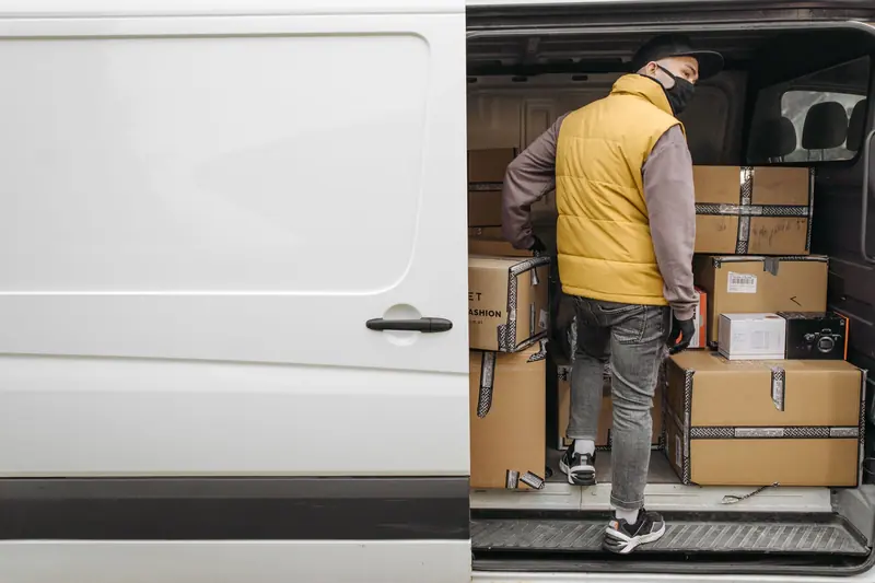 Transporter wird mit Kartons beladen – Möbeltransport