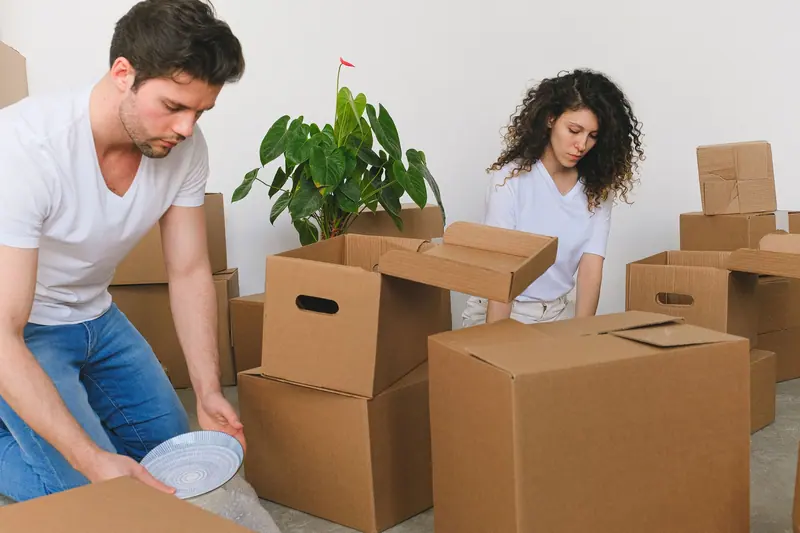 Paar packt Umzugskartons in der Wohnung – Privatumzug