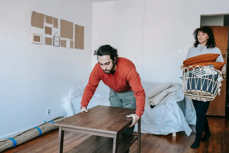 Zwei Personen räumen Möbel aus einer Wohnung – Haushaltsauflösung