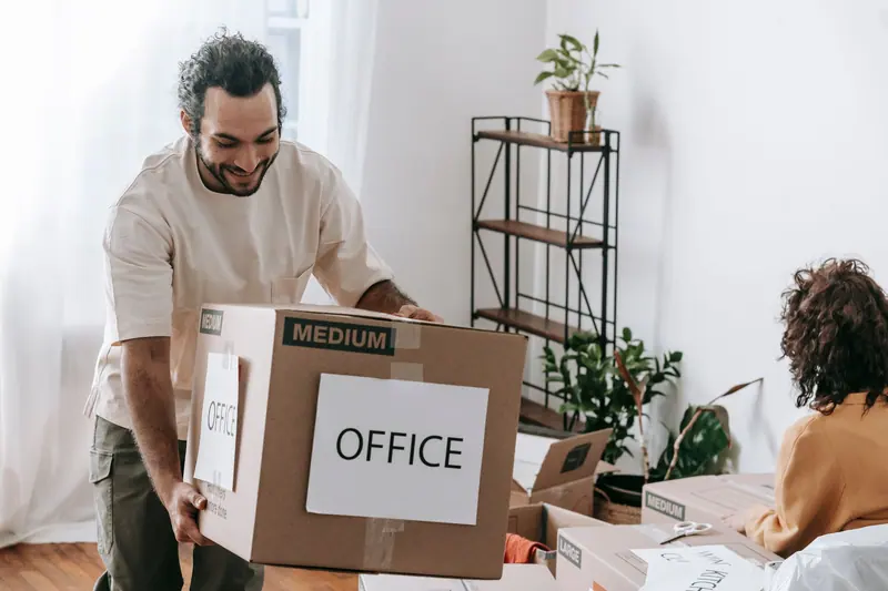 Mitarbeiter packt Bürokarton – Büroumzug