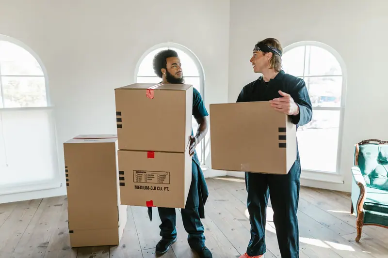 Zwei Umzugshelfer mit Kartons