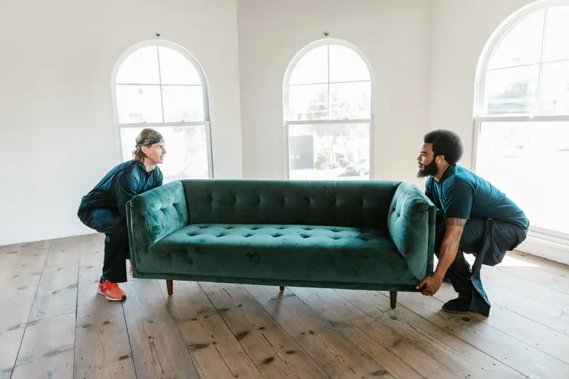 Möbelträger heben ein Sofa an