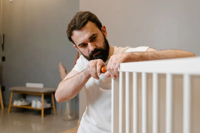Monteur baut ein Kinderbett auf – Möbelmontage