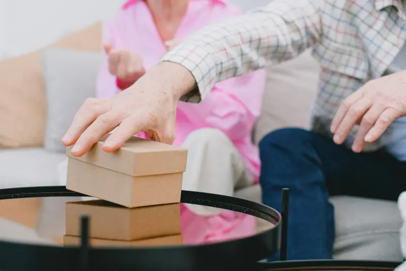 Ältere Person packt kleine Kartons – Seniorenumzug
