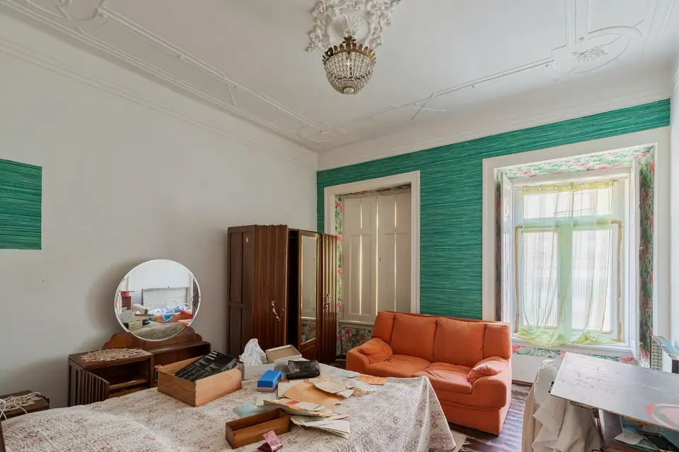 Zimmer in einem Altbau während der Entrümpelung mit Kartons und alten Möbeln