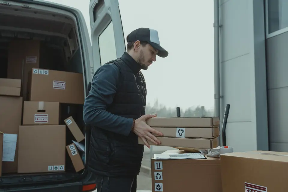 Umzugshelfer lädt Kartons aus einem Transporter